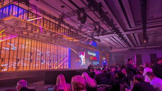 The Splunk keynote hall at Splunk .conf24 in Caesars Forum, lit in orange and purple light.