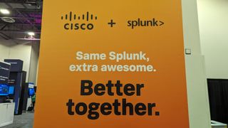 The Cisco and Splunk logos next to each other on an orange banner on the conference floor at Splunk .conf24 in the Venetian, Las Vegas,, with text beneath reading "Same Splunk, extra awesome. Better Together."