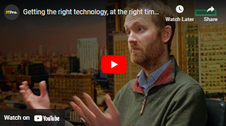 Webinar screen with image of man with raised hands in conversation and cityscape behind him