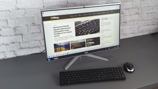 A photograph of the Acer Aspire C24 on a desk with mouse and keyboard