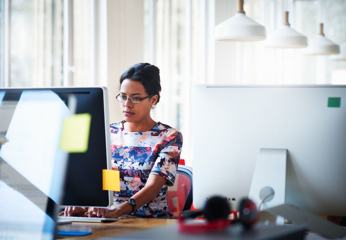 Female office worker working a computer behind a desk