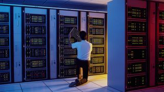 Mainframe modernization concept image showing a man in a server room inspecting a mainframe computer.