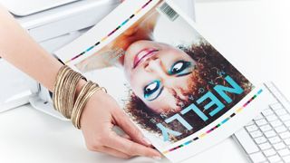 A woman holding a freshly printer test page for a magazine cover