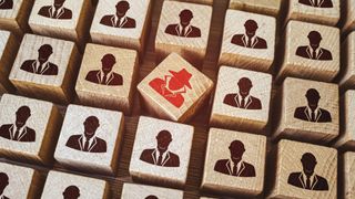 Red insider threat painted on Wooden cube surrounded by others with employee icons