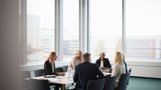 Boardroom meeting with executives discussing business issues, including CTO, CISO, CIO, and CEO.